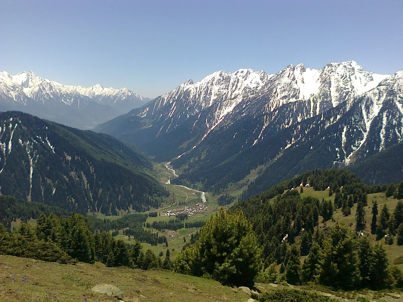 Aru village in its green valley below snow-capped Himalayan peaks, seen from the slopes of Birzamal near Pahalgam