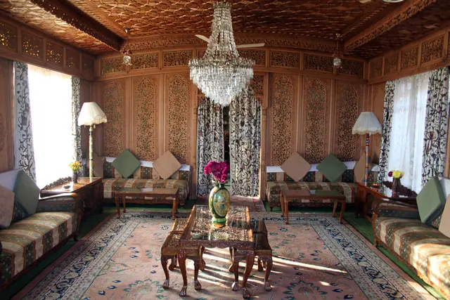 Drawing room of a Kashmiri houseboat with hand-carved walnut panelling, khatamband ceiling, crewel curtains and chandelier