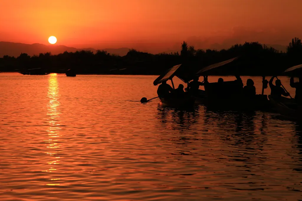 Silhouetted shikaras on Dal Lake as the sun sets over the hills of Srinagar
