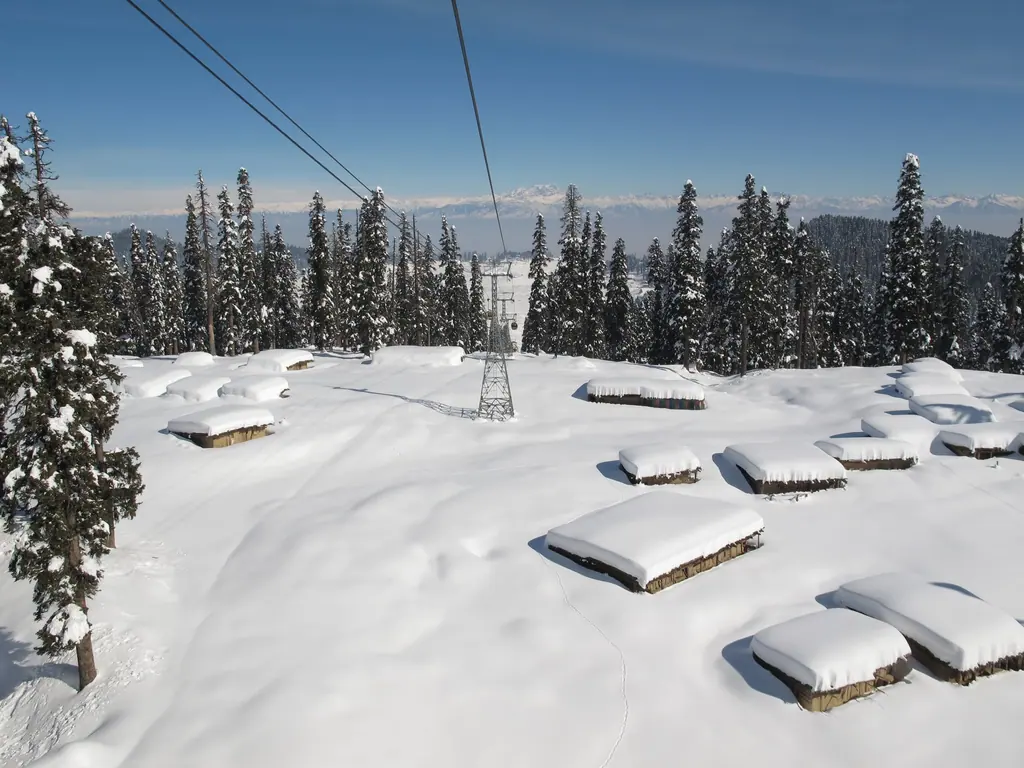 Deep snow blanketing the slopes of Gulmarg seen from the Gulmarg Gondola, snow-laden firs and the Pir Panjal range beyond